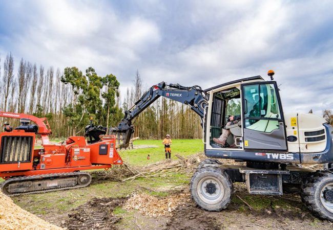 Using an excavator to mulch logs